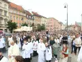 26 czerwca. Procesja z kapłanami w strojach liturgicznych i wiernymi maszeruje ulicą w otoczeniu zabytkowych kamienic.