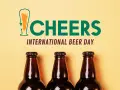 Trzy butelki piwa na żółtym tle. Napis "CHEERS INTERNATIONAL BEER DAY" świętuje dzień piwa.