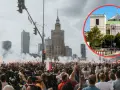 Tłum z flagami i racami na tle Pałacu Kultury. 21 sierpnia to święto upamiętniające ważne wydarzenia.