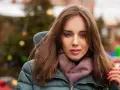 Weronika w zimowej kurtce i szaliku, z choinką w tle. Czas na świętowanie, kiedy są imieniny Weroniki!