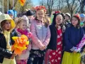 Dzieci w barwnych strojach, z kwiatami i ozdobami, świętują dzień zięcia.