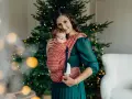 26 października nietypowe święta. Mama z dzieckiem w chuście przy choince, otuleni ciepłem i świąteczną atmosferą.
