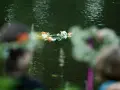 Wianek z kwiatów płynie po wodzie. 23 czerwca, w noc Kupały, ludzie wrzucają wianki do rzeki.