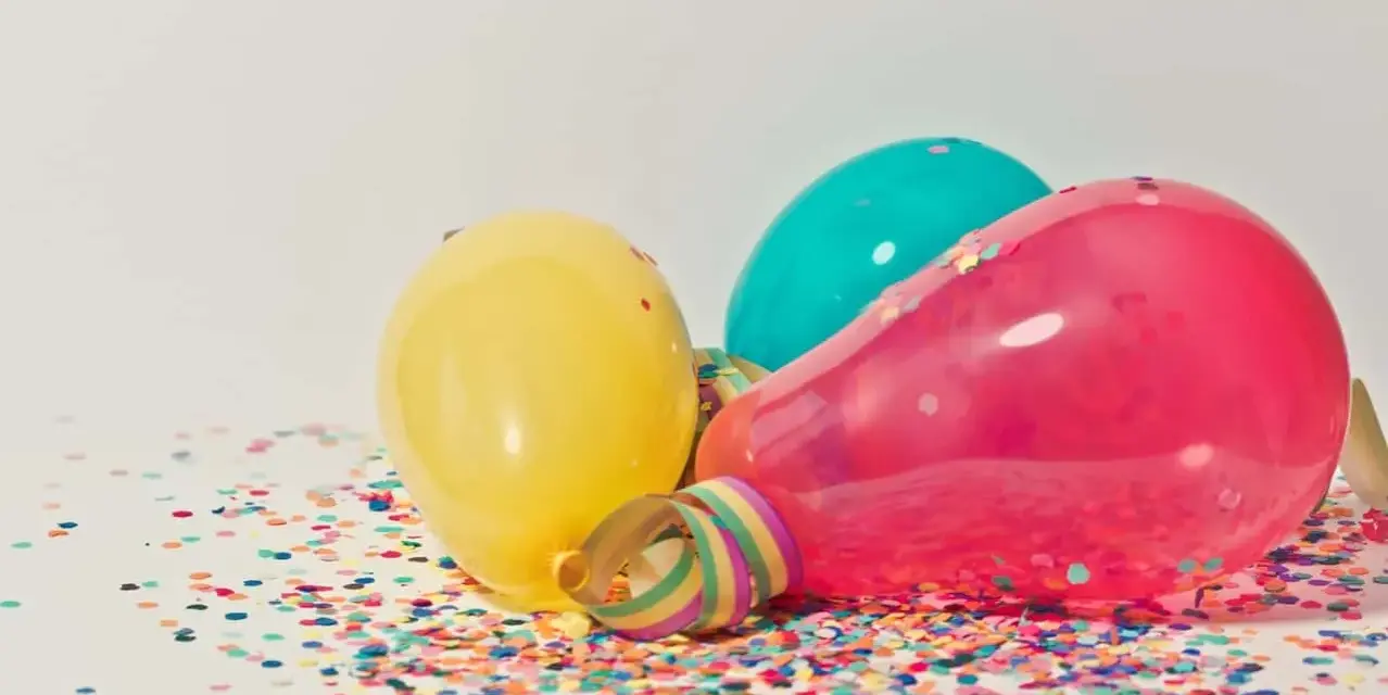 Kolorowe balony i konfetti na stole, gotowe na imieniny Natana.