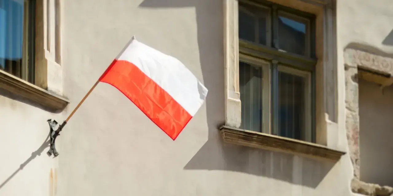 Biało-czerwona flaga powiewa na ścianie kamienicy. Nawet w styczniu czuć ducha świąt narodowych.