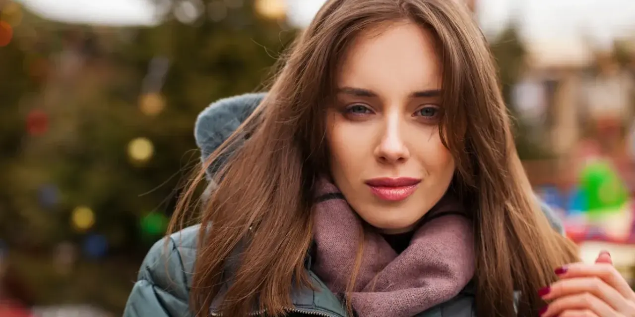 Weronika w zimowej kurtce i szaliku, z choinką w tle. Czas na świętowanie, kiedy są imieniny Weroniki!
