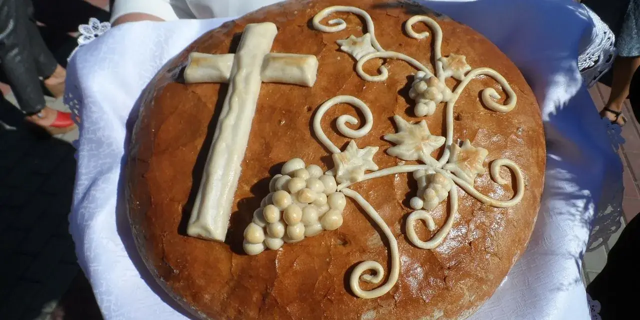 Chleb dożynkowy z krzyżem i winogronami, symbolizujący dożynki tradycja i obyczaje.