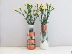 Dwa szklane wazony DIY z kwiatami. Jeden w paski miedziane, drugi z miedzianym ombre i białym dołem.