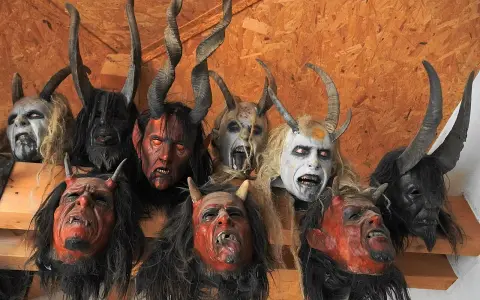 Krampus co to? Zobacz przerażające maski z rogami i kłami, które zdobią ścianę.