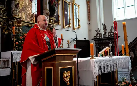 Uroczystość imieniny Bartłomieja w kościele. Kapłan w czerwonej dalmatyce przemawia przy ambonie.