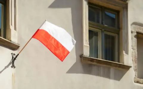 Biało-czerwona flaga powiewa na ścianie kamienicy. Nawet w styczniu czuć ducha świąt narodowych.