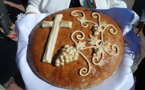 Chleb dożynkowy z krzyżem i winogronami, symbolizujący dożynki tradycja i obyczaje.
