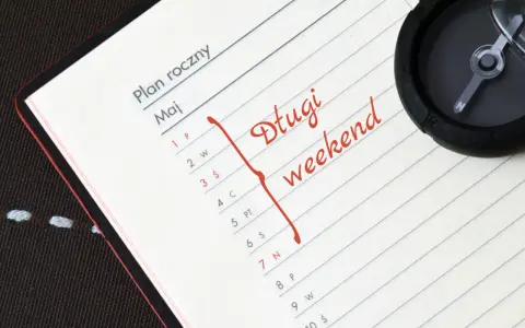 Plan roczny na maj. Czerwonym flamastrem zaznaczono "Długi weekend". Kompas sugeruje podróż w 2030 roku.