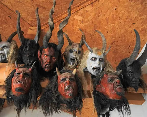 Krampus co to? Zobacz przerażające maski z rogami i kłami, które zdobią ścianę.