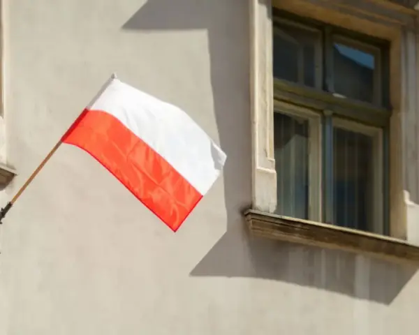 Biało-czerwona flaga powiewa na ścianie kamienicy. Nawet w styczniu czuć ducha świąt narodowych.