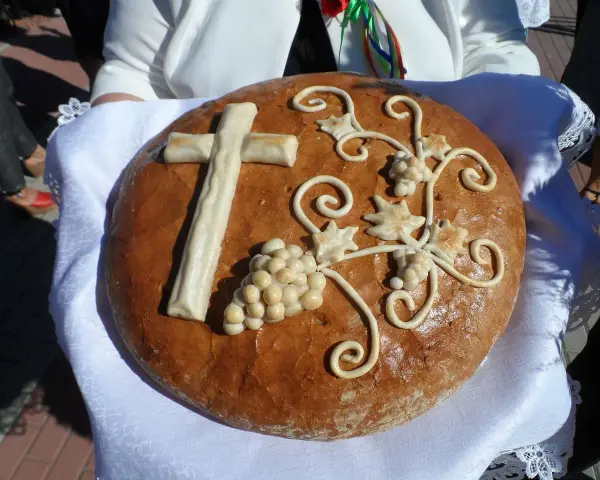Chleb dożynkowy z krzyżem i winogronami, symbolizujący dożynki tradycja i obyczaje.