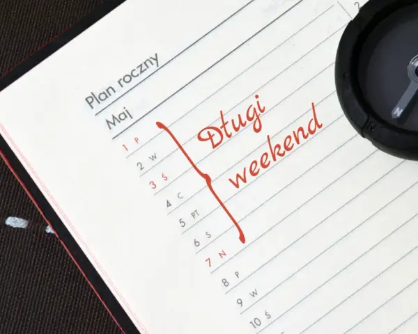 Plan roczny na maj. Czerwonym flamastrem zaznaczono "Długi weekend". Kompas sugeruje podróż w 2030 roku.