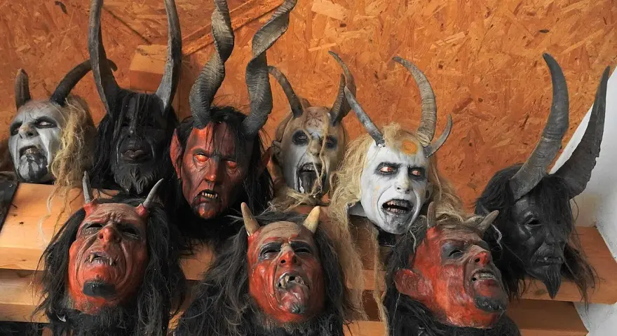 Krampus co to? Zobacz przerażające maski z rogami i kłami, które zdobią ścianę.