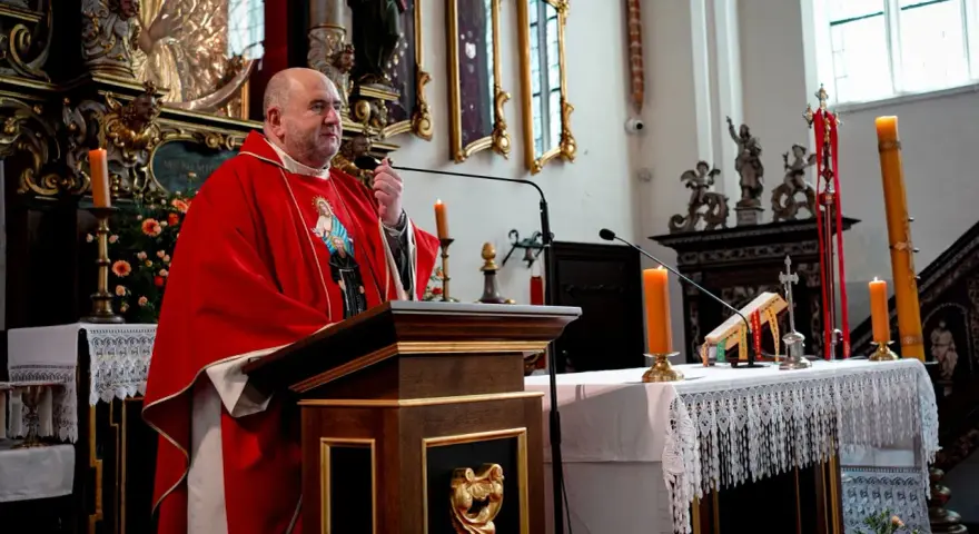 Uroczystość imieniny Bartłomieja w kościele. Kapłan w czerwonej dalmatyce przemawia przy ambonie.