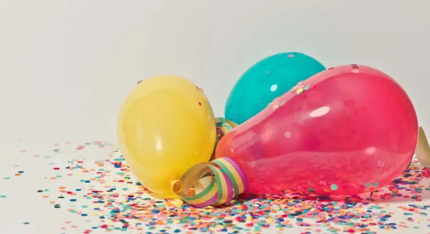 Kolorowe balony i konfetti na stole, gotowe na imieniny Natana.
