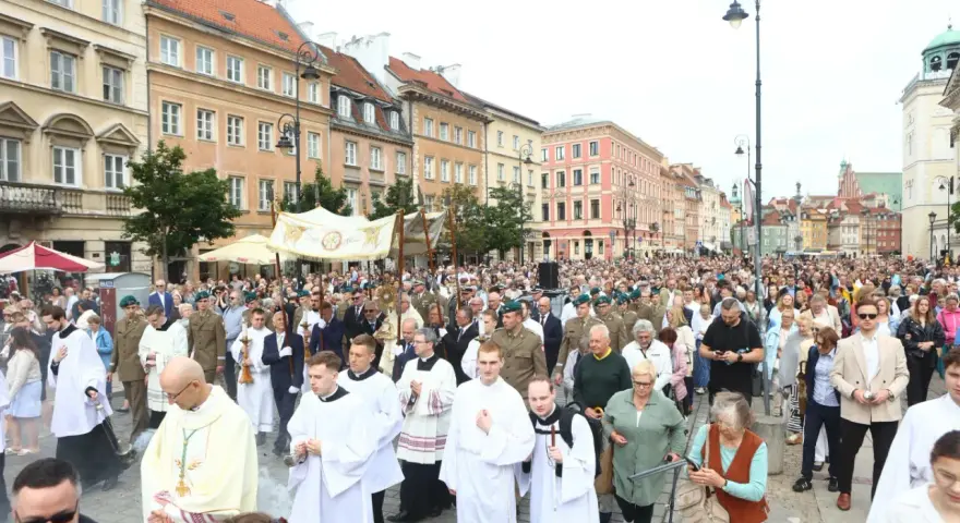 26 czerwca. Procesja z kapłanami w strojach liturgicznych i wiernymi maszeruje ulicą w otoczeniu zabytkowych kamienic.