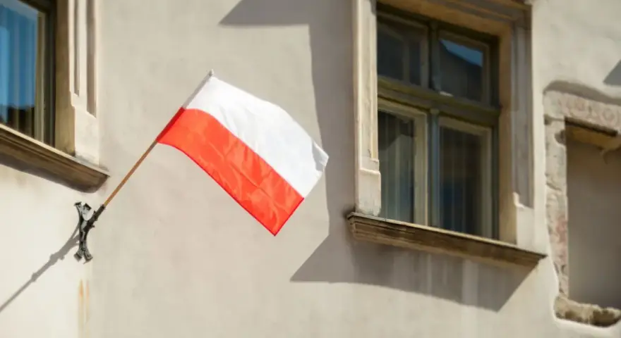 Biało-czerwona flaga powiewa na ścianie kamienicy. Nawet w styczniu czuć ducha świąt narodowych.