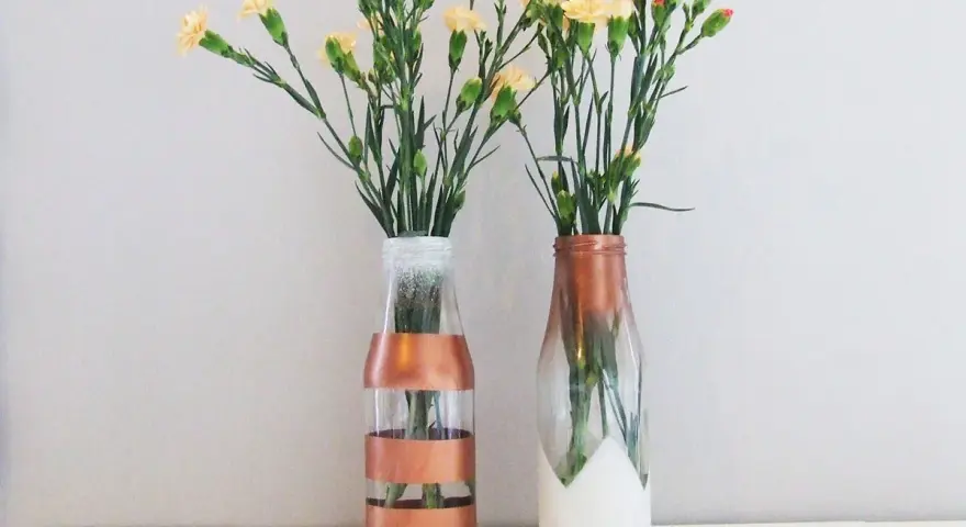 Dwa szklane wazony DIY z kwiatami. Jeden w paski miedziane, drugi z miedzianym ombre i białym dołem.