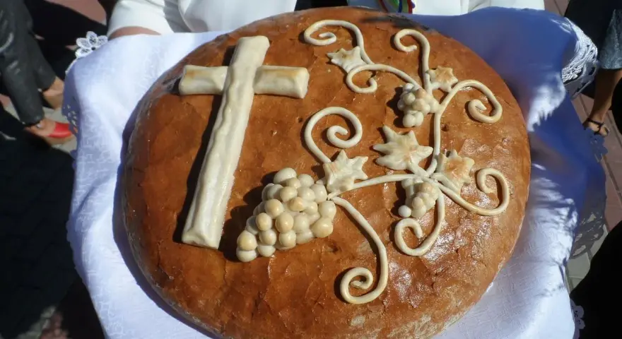Chleb dożynkowy z krzyżem i winogronami, symbolizujący dożynki tradycja i obyczaje.