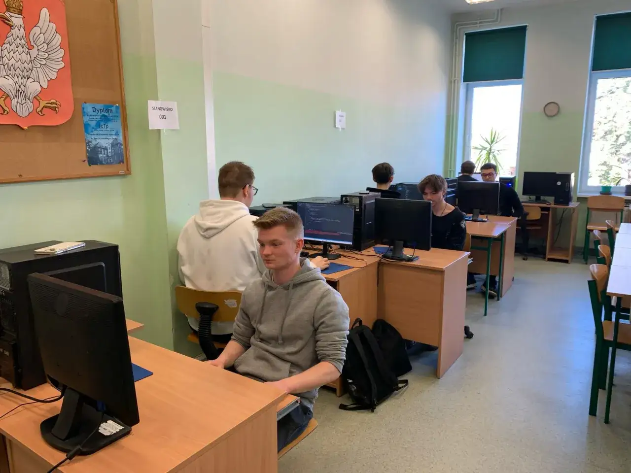 Uczniowie przy komputerach świętują dzień informatyka.