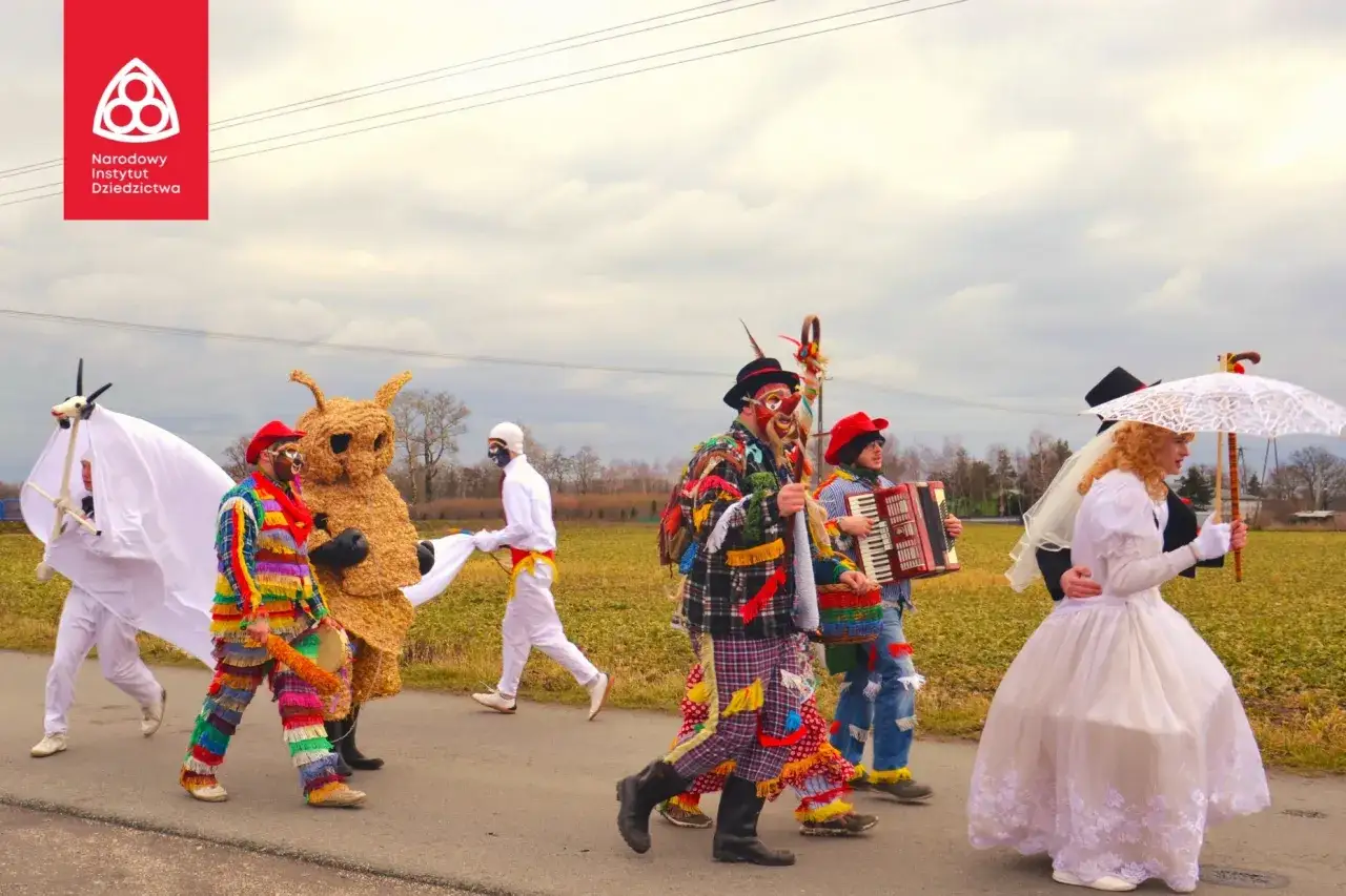 Kolorowy korowód w barwnych strojach i maskach, z akordeonistą i panną młodą z parasolką, celebruje ostatki zapusty inaczej.