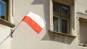 Biało-czerwona flaga powiewa na ścianie kamienicy. Nawet w styczniu czuć ducha świąt narodowych.