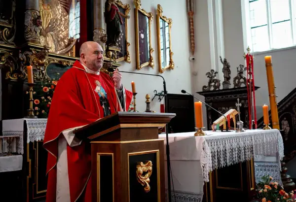 Uroczystość imieniny Bartłomieja w kościele. Kapłan w czerwonej dalmatyce przemawia przy ambonie.