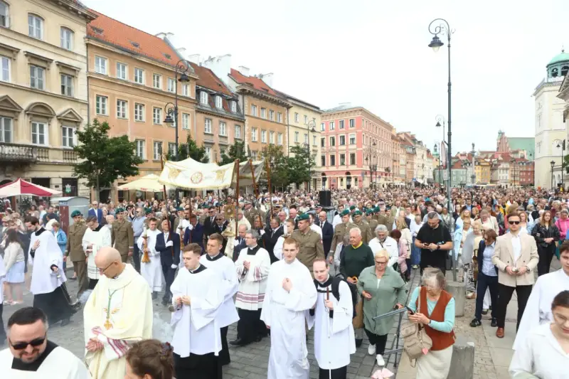 26 czerwca. Procesja z kapłanami w strojach liturgicznych i wiernymi maszeruje ulicą w otoczeniu zabytkowych kamienic.
